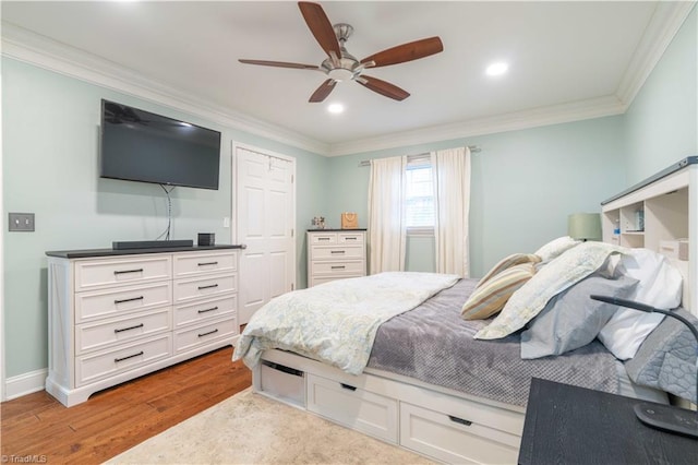 bedroom featuring baseboards, ceiling fan, wood finished floors, and crown molding