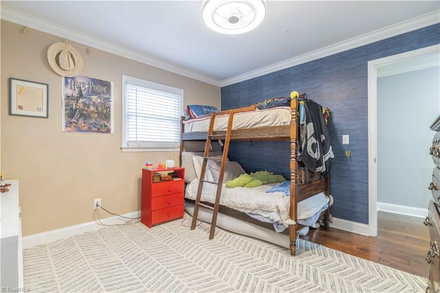 bedroom with baseboards, crown molding, and wood finished floors