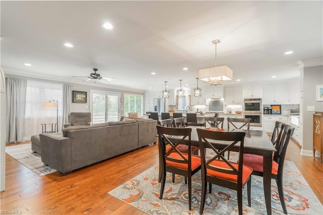 dining area featuring light wood-style flooring, ornamental molding, a ceiling fan, and recessed lighting