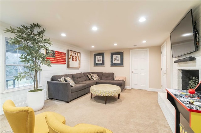 living area with recessed lighting, a brick fireplace, light carpet, and baseboards