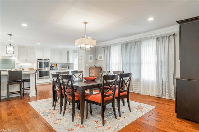 dining area with light wood-style floors, recessed lighting, and ornamental molding