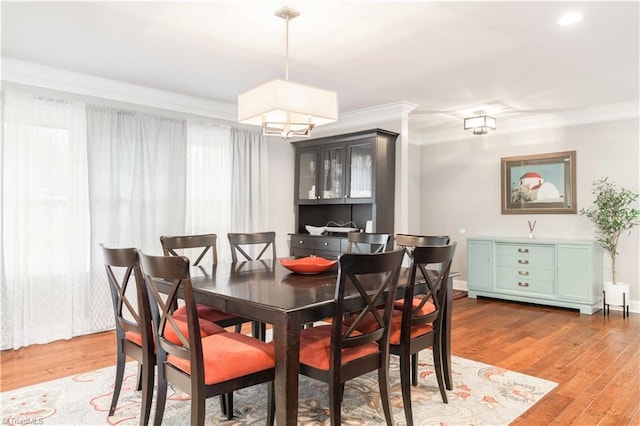 dining space featuring ornamental molding, a healthy amount of sunlight, and light wood finished floors