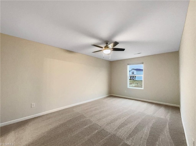 carpeted spare room featuring ceiling fan