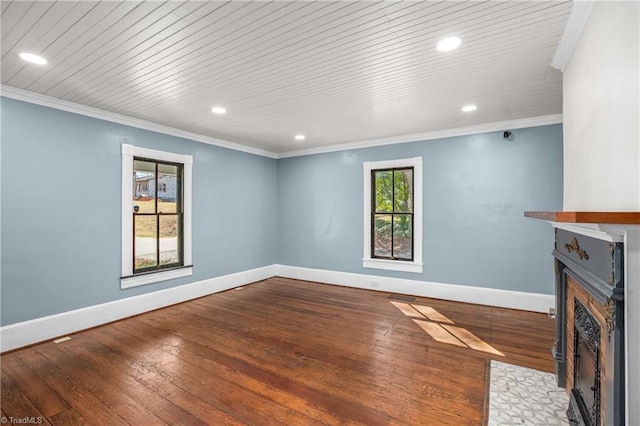 unfurnished living room featuring a fireplace with flush hearth, hardwood / wood-style floors, baseboards, and ornamental molding