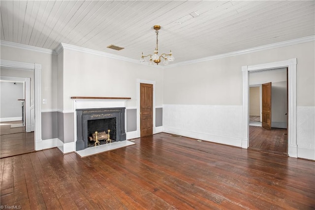 unfurnished living room with hardwood / wood-style floors, a wainscoted wall, a fireplace, ornamental molding, and a notable chandelier