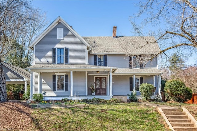 view of front of house with covered porch, a chimney, a front yard, and a shingled roof