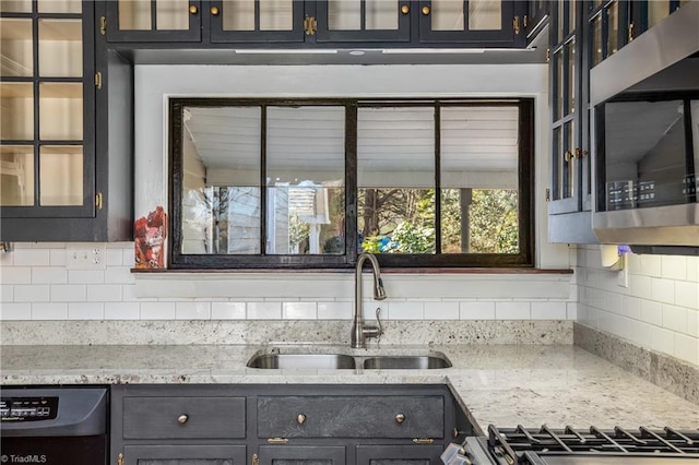 kitchen with a sink, stainless steel microwave, backsplash, glass insert cabinets, and dishwasher