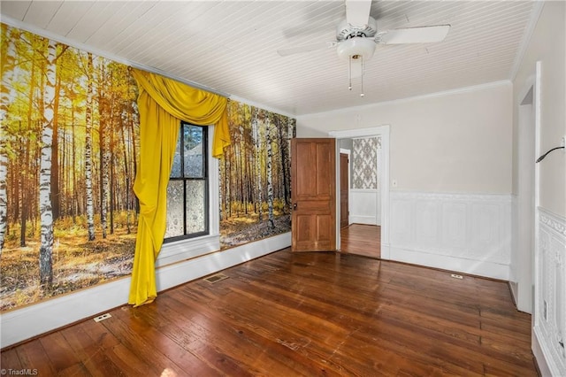 unfurnished room featuring a wainscoted wall, ornamental molding, a ceiling fan, and hardwood / wood-style floors