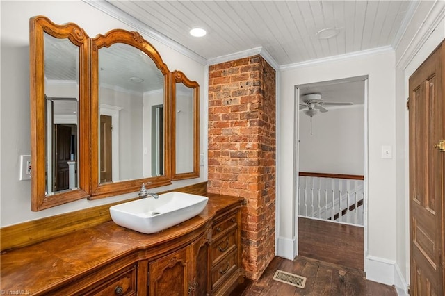 bathroom with crown molding, wood finished floors, visible vents, and ceiling fan