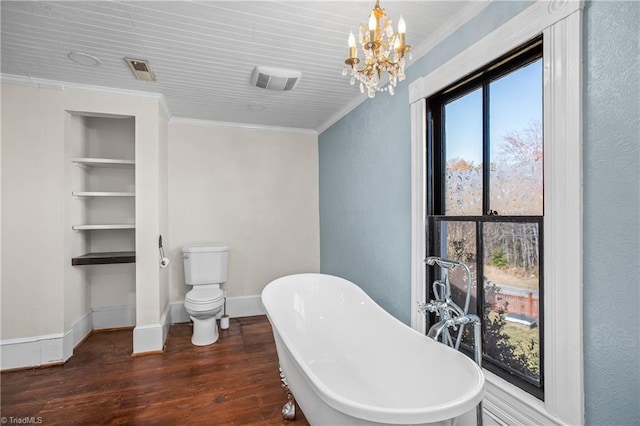 bathroom with a notable chandelier, wood finished floors, a soaking tub, and ornamental molding