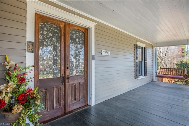 property entrance featuring covered porch and french doors