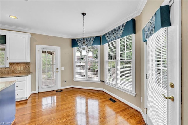 608 Greyrock Rd, Whitsett, NC 27377 - unfurnished dining area with crown molding, a chandelier, light wood finished floors, and baseboards