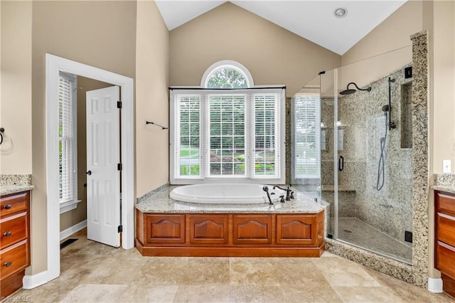 608 Greyrock Rd, Whitsett, NC 27377 - full bathroom with vanity, vaulted ceiling, a stall shower, and a garden tub