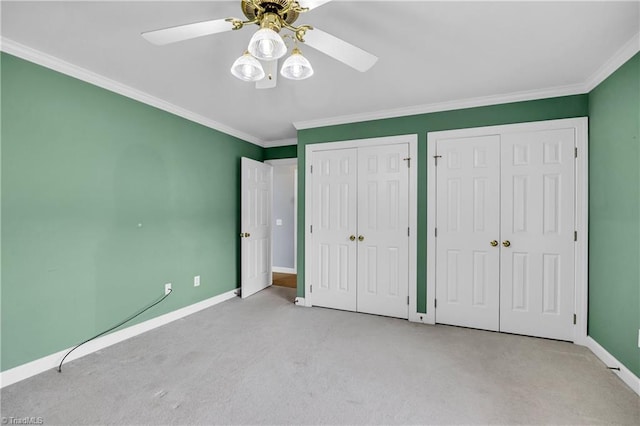 608 Greyrock Rd, Whitsett, NC 27377 - unfurnished bedroom with two closets, carpet flooring, crown molding, baseboards, and a ceiling fan