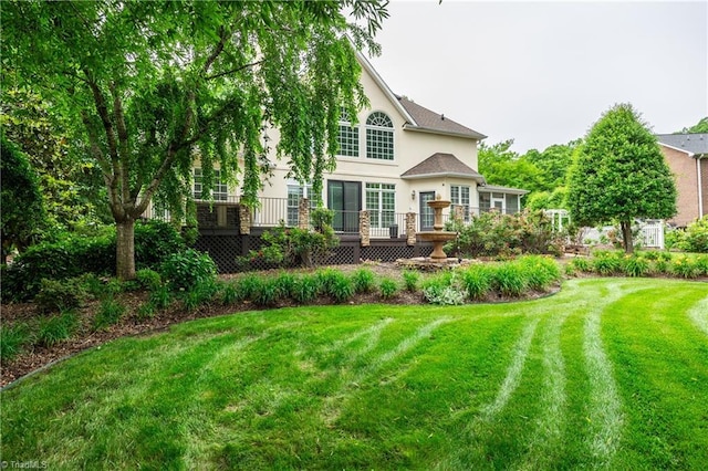 608 Greyrock Rd, Whitsett, NC 27377 - rear view of house with stucco siding, a lawn, and a deck