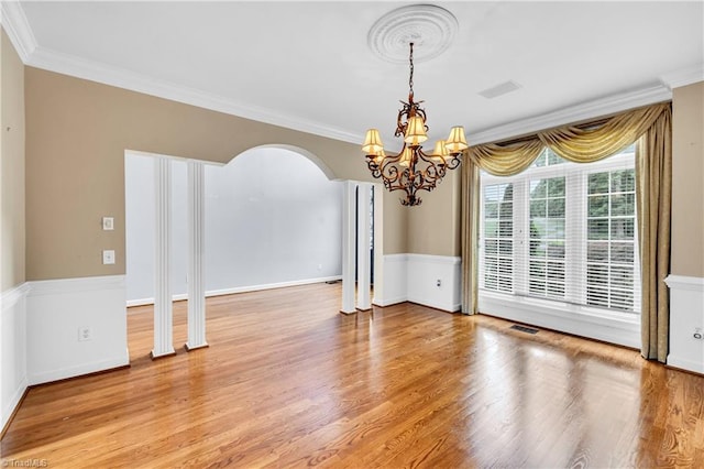 608 Greyrock Rd, Whitsett, NC 27377 - empty room with a chandelier, ornamental molding, arched walkways, wood finished floors, and baseboards
