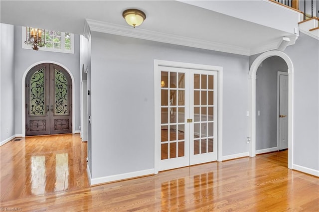 608 Greyrock Rd, Whitsett, NC 27377 - foyer featuring french doors, arched walkways, wood finished floors, a chandelier, and crown molding