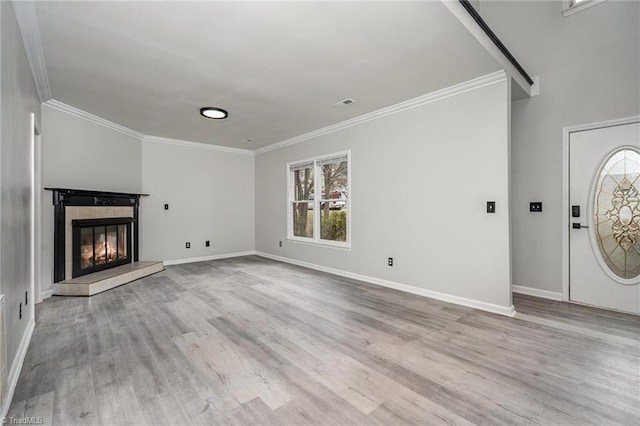 unfurnished living room featuring a healthy amount of sunlight, light wood-type flooring, and ornamental molding