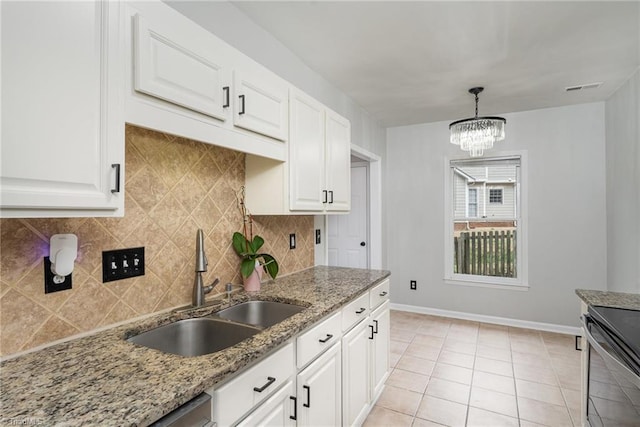 kitchen featuring sink, hanging light fixtures, light tile patterned floors, light stone counters, and white cabinets