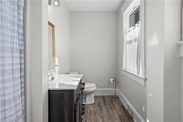 bathroom with a shower with curtain, vanity, wood-type flooring, and toilet