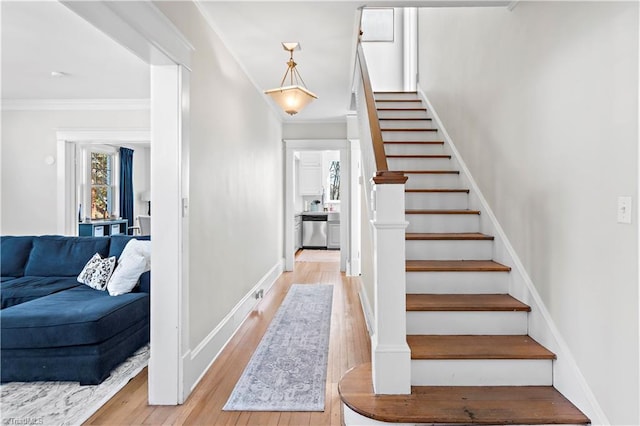 stairs featuring hardwood / wood-style flooring and crown molding