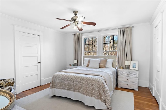 bedroom with ceiling fan, wood-type flooring, and ornamental molding