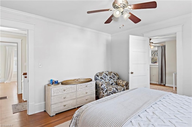 bedroom featuring ceiling fan, hardwood / wood-style floors, and ornamental molding