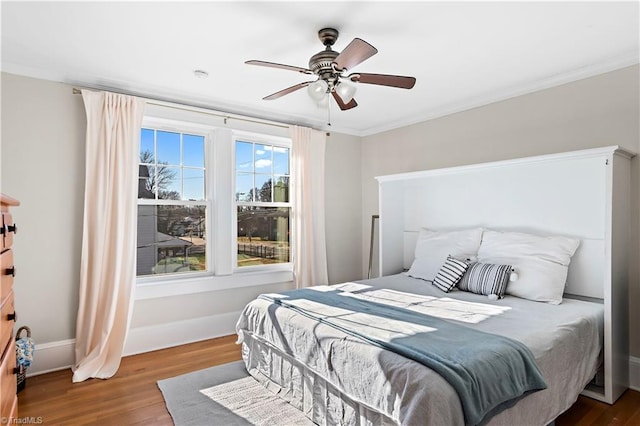 bedroom with hardwood / wood-style floors, ceiling fan, and ornamental molding