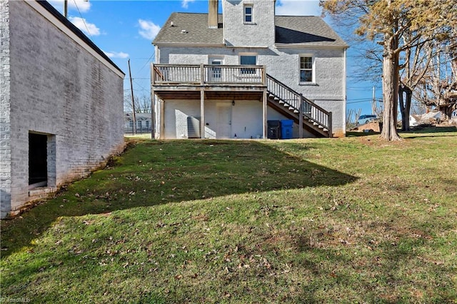 rear view of property with a yard and a wooden deck