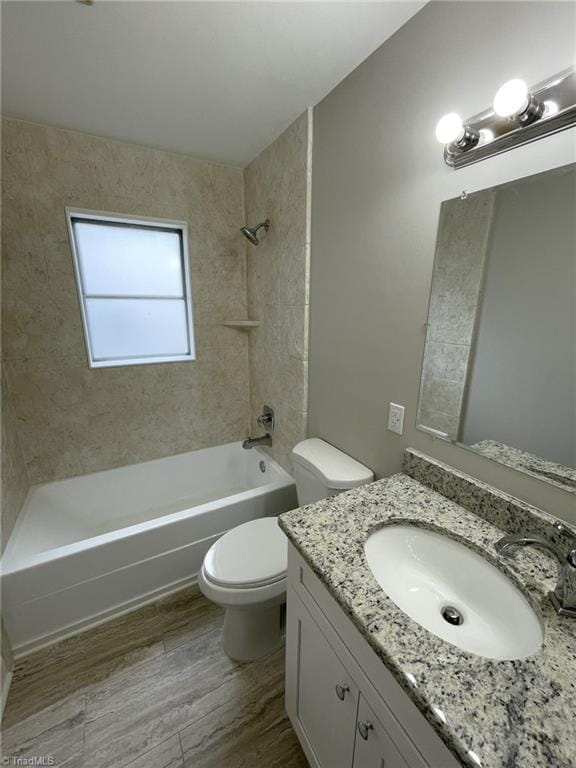 full bathroom featuring vanity, tiled shower / bath combo, toilet, and wood-type flooring