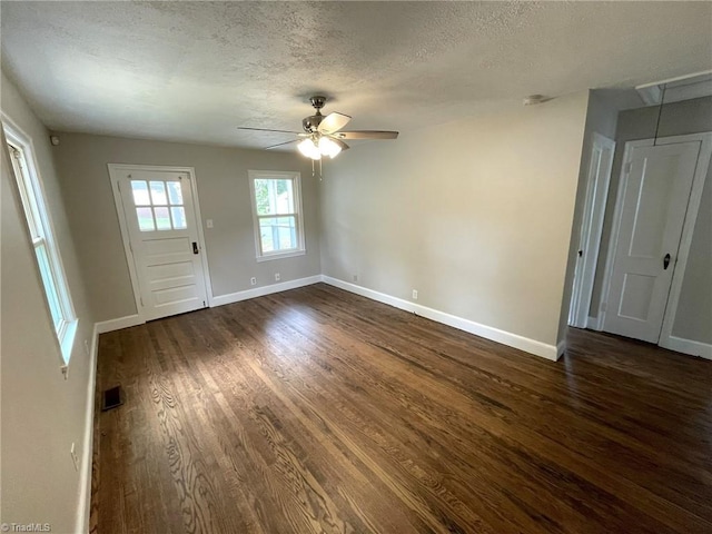 interior space with ceiling fan, dark wood-type flooring, and a textured ceiling