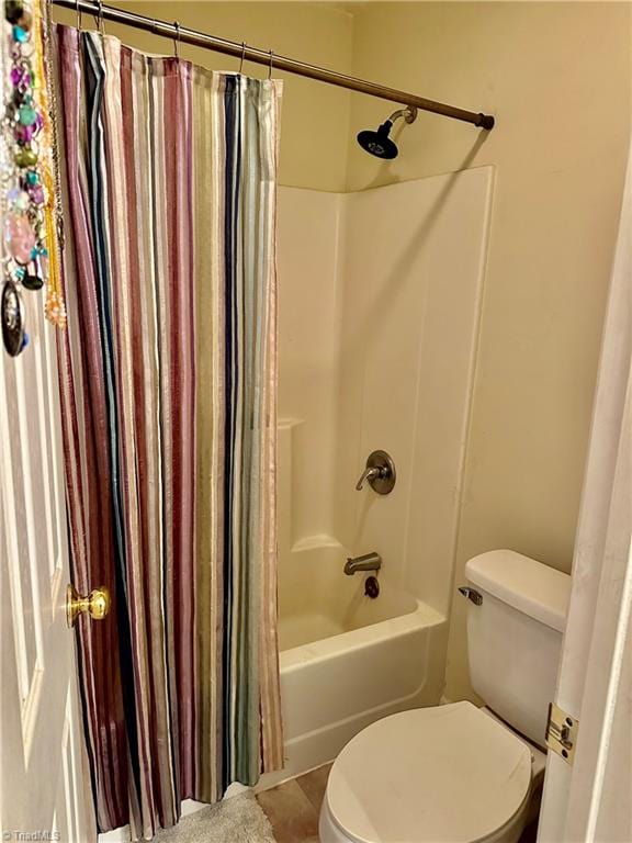 bathroom featuring tile patterned flooring, toilet, and shower / bathtub combination with curtain