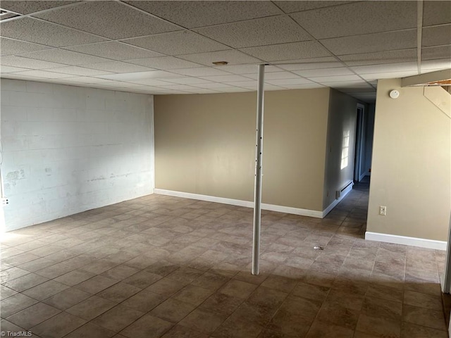 basement with a baseboard radiator and a paneled ceiling