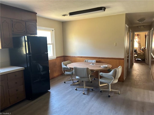 dining space featuring hardwood / wood-style flooring and wood walls