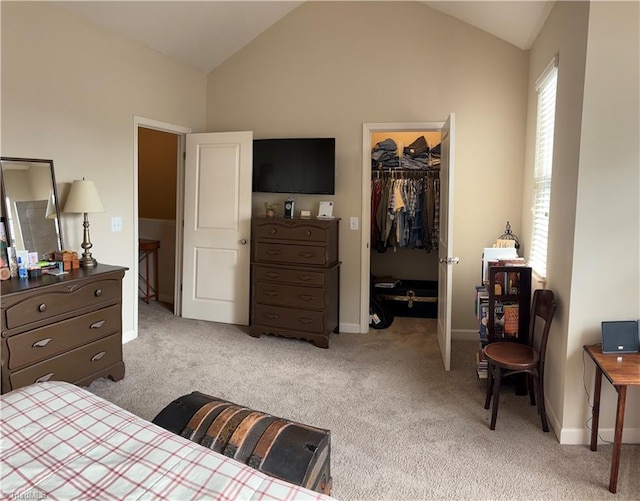 bedroom featuring a closet, light colored carpet, vaulted ceiling, and a spacious closet