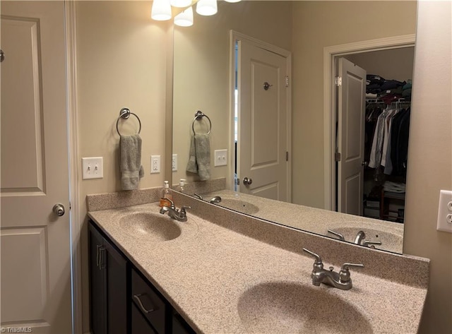 full bath featuring double vanity, a spacious closet, and a sink