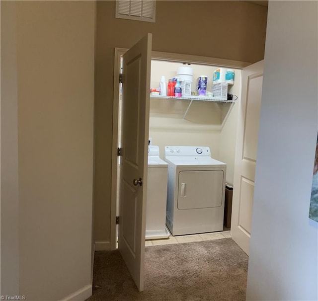 laundry area with visible vents, washing machine and dryer, carpet flooring, laundry area, and tile patterned floors