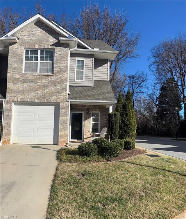 view of front of home with brick siding, a shingled roof, concrete driveway, a front yard, and a garage