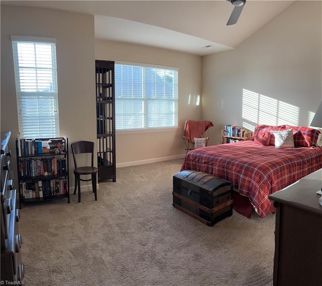 bedroom with carpet floors, multiple windows, vaulted ceiling, and baseboards