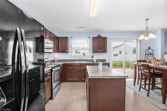 4385 Morning Ridge Ln, Winston-Salem, NC 27101 - kitchen featuring appliances with stainless steel finishes, a kitchen island, a chandelier, hanging light fixtures, and light flooring