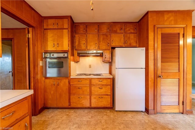 kitchen featuring white appliances and wooden walls