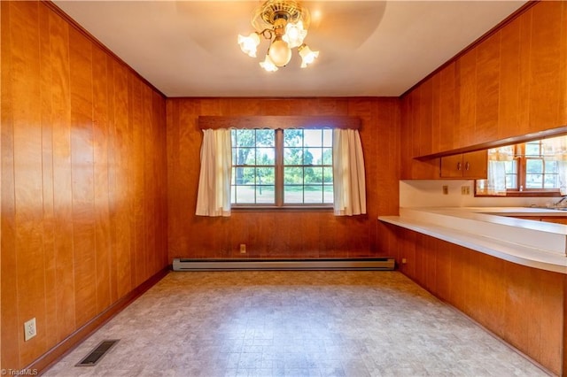 interior space with a baseboard radiator, an inviting chandelier, and wooden walls