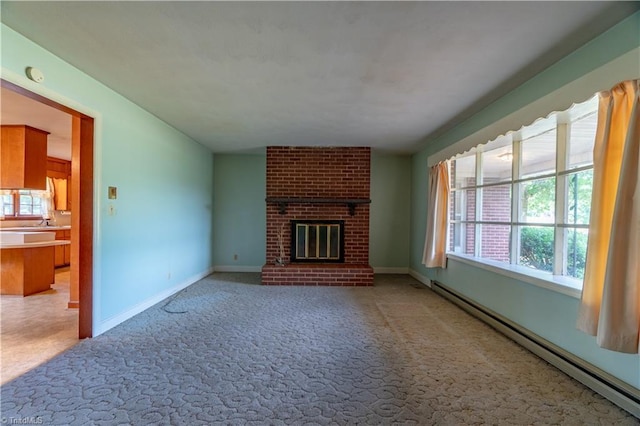 unfurnished living room with a brick fireplace, sink, carpet, and a baseboard radiator