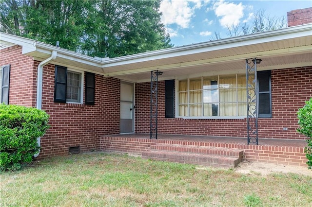 property entrance featuring covered porch and a yard