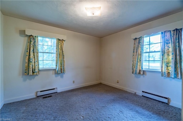 unfurnished room with carpet, plenty of natural light, and a baseboard heating unit