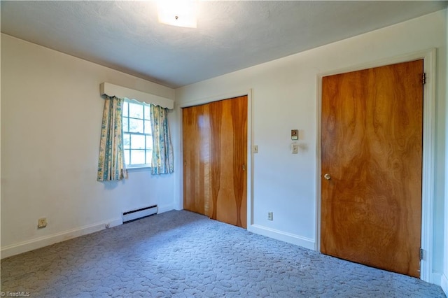 unfurnished bedroom with baseboard heating, a closet, and carpet