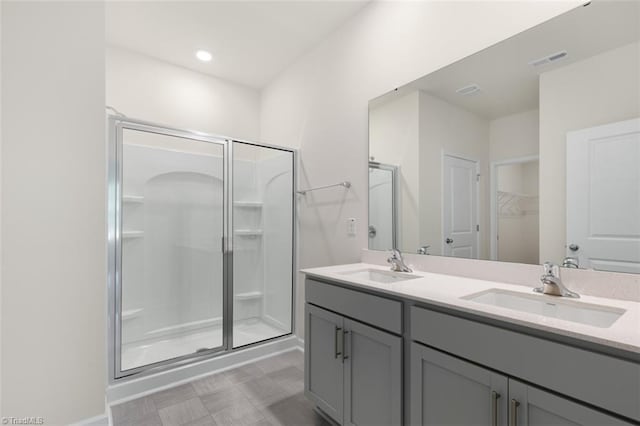 bathroom with vanity and a shower with door