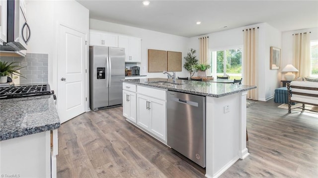 kitchen with a center island with sink, white cabinets, and appliances with stainless steel finishes