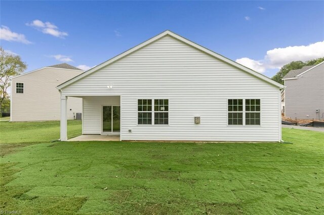 rear view of house featuring a patio area and a yard