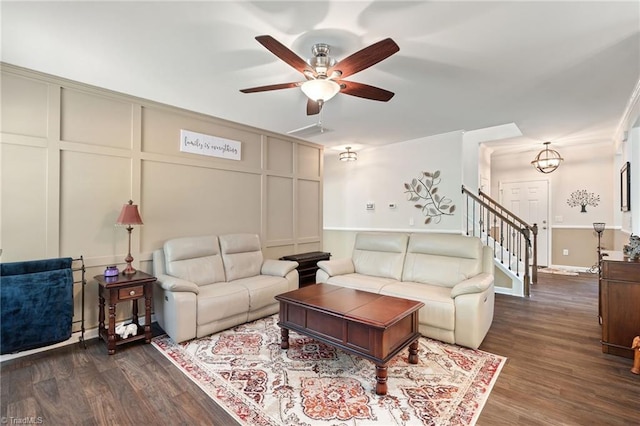 1951 Rubywood St, Greensboro, NC 27405 - living room featuring ceiling fan, a decorative wall, dark wood-style floors, crown molding, and stairway